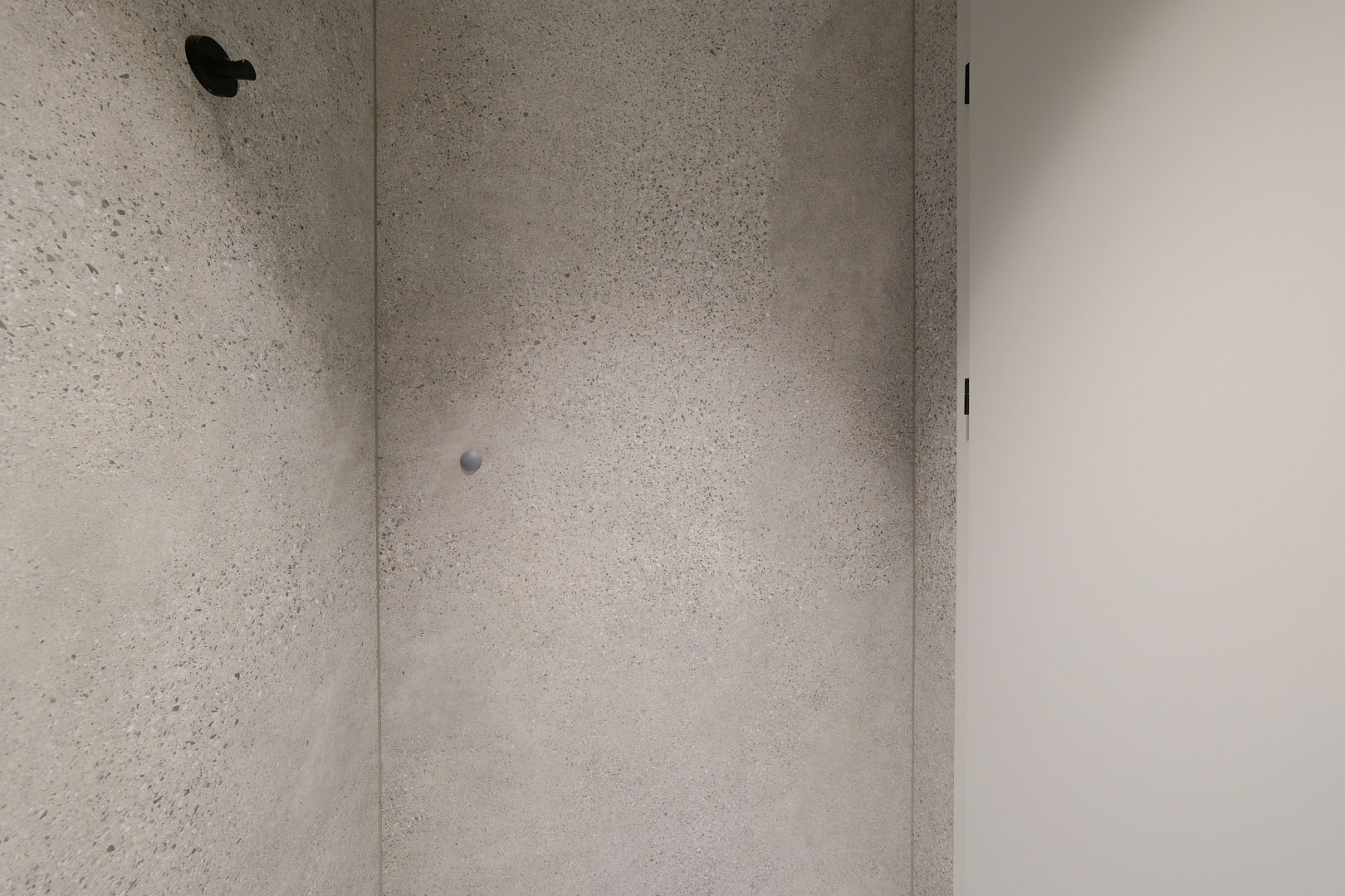 Toaleta męska w projekcie wnętrza biurowego z okładziną terrazzo