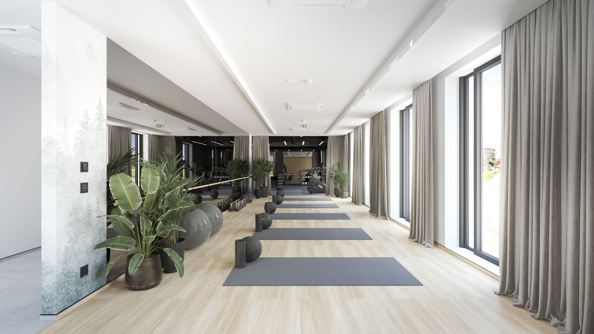 Jasna strefa fitness w przestrzeni coworkingowej z matami do ćwiczeń, dużymi przeszkleniami, zasłonami i naturalnym światłem